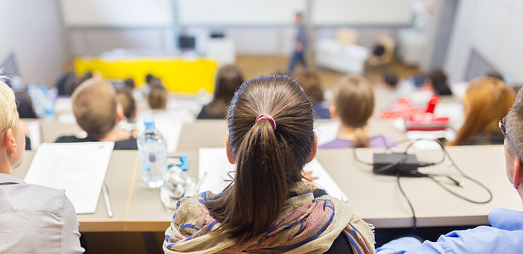 Viele junge Menschen sitzen in einem Hörsaal