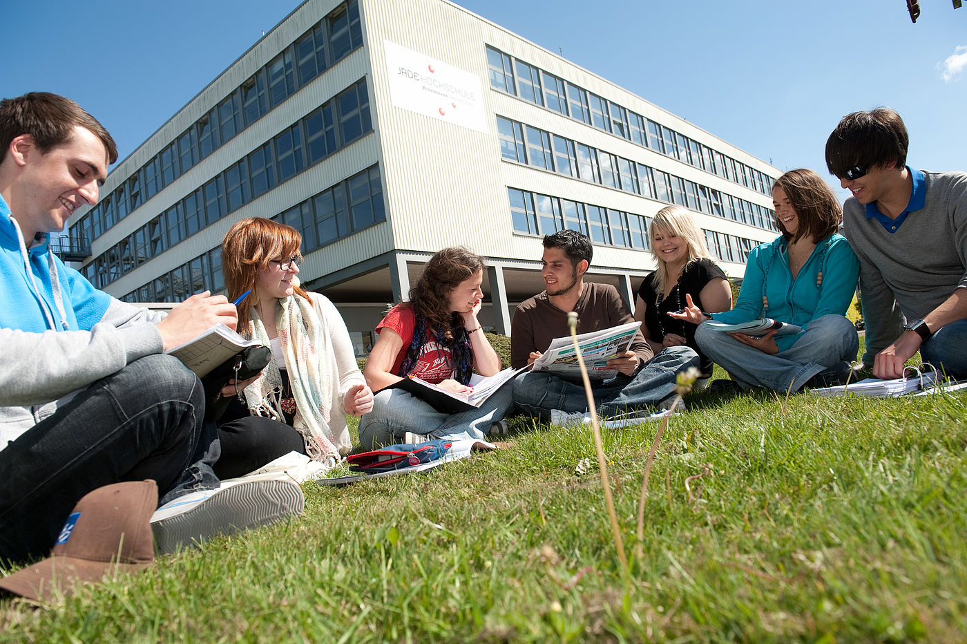 Studierende lernen gemeinsam auf einer Wiese am Campus Wilhelmshaven der Jade HS 