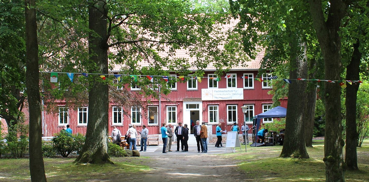 Hochschulgebäude der FIT Hermannsburg mit Menschengruppe davor